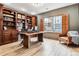 Beautiful home office featuring custom wood built-ins, hardwood floors, and natural light from a large window at 1575 Ridgetrail Ct, Castle Rock, CO 80104