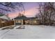 Charming single-story home showcasing a brick exterior, grey accents, and a snow-covered front yard at 1534 Rosemary St, Denver, CO 80220