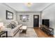 Comfortable living room featuring hardwood floors, a decorative rug, and a wall-mounted television at 1534 Rosemary St, Denver, CO 80220