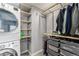 Functional walk-in closet with built-in shelves and a washer/dryer unit for added convenience at 1534 Rosemary St, Denver, CO 80220