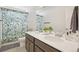 Bright bathroom featuring a double sink vanity, white countertop, and a decorative shower curtain at 545 High Point Dr, Longmont, CO 80504