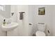 A white sink and toilet with a framed San Francisco art print on the wall at 545 High Point Dr, Longmont, CO 80504