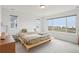 Sunlit bedroom with a minimalist platform bed and large windows overlooking scenic views at 545 High Point Dr, Longmont, CO 80504