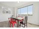 Bright dining area with a wooden table, red chairs, and a large window at 545 High Point Dr, Longmont, CO 80504