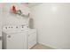 Clean laundry room featuring a white washer and dryer with an ironing board at 545 High Point Dr, Longmont, CO 80504