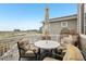 Outdoor patio with a white table, cushioned chairs, umbrella, and a decorative hanging chair at 545 High Point Dr, Longmont, CO 80504