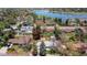 An aerial view of homes near a lake, showing tree coverage, lawns, roads, and a car driving at 12375 W 19Th Pl, Lakewood, CO 80215