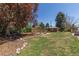 Spacious backyard featuring a wooden shed, a fire pit area, and a lush lawn at 12375 W 19Th Pl, Lakewood, CO 80215