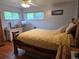 Well-lit bedroom featuring a wooden bed frame, hardwood floors, and natural light from two windows at 12375 W 19Th Pl, Lakewood, CO 80215