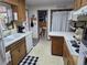 Functional kitchen with white appliances, wood cabinets, and a view into the adjacent dining area at 12375 W 19Th Pl, Lakewood, CO 80215