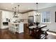 Bright modern kitchen with white cabinets, stainless appliances, a large island, and a wooden dining table set at 865 Oleander St, Castle Rock, CO 80109