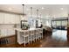Modern kitchen with white cabinets, an island with seating, and stainless steel appliances overlooking the living room at 865 Oleander St, Castle Rock, CO 80109