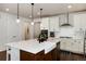 Bright kitchen with white cabinetry, a large island with a farmhouse sink, stainless steel appliances and a subway tile backsplash at 865 Oleander St, Castle Rock, CO 80109
