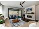 Bright living room with comfy seating, a fireplace, a ceiling fan, and sliding glass doors leading to an outside patio at 865 Oleander St, Castle Rock, CO 80109
