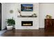 Bright living room features a modern fireplace, wood mantle, and stone surround, complemented by stylish decor and hardwood floors at 865 Oleander St, Castle Rock, CO 80109