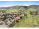 Aerial view showing the home's setting within a residential area bordered by green space and hills at 9 Amaranth Dr, Littleton, CO 80127