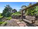 Backyard landscape with a stone wall, terraced gardens and a wooden swing bench at 9 Amaranth Dr, Littleton, CO 80127