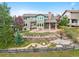 Aerial view of the backyard featuring a stone patio, landscaped areas, and an outdoor swing at 9 Amaranth Dr, Littleton, CO 80127