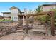 Landscaped backyard with stone retaining wall, rustic swing, and access to the home's rear entrance at 9 Amaranth Dr, Littleton, CO 80127
