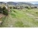 Large grassy field behind the home, with views of rolling hills and scattered houses in the distance at 9 Amaranth Dr, Littleton, CO 80127