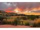 Expansive backyard view with colorful sunset over mountains from stone patio and lush landscaping at 9 Amaranth Dr, Littleton, CO 80127