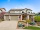Charming two-story home featuring a three-car garage, covered porch, and professionally landscaped front yard at 9 Amaranth Dr, Littleton, CO 80127