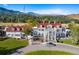 Grand historic home boasting a red roof, white exterior, and circular driveway leading to the entrance at 9 Amaranth Dr, Littleton, CO 80127
