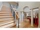 Grand foyer with staircase, hardwood floors, rod iron banister and arched entry to living room at 9 Amaranth Dr, Littleton, CO 80127