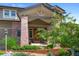 Inviting front porch featuring brick columns, a covered entrance, and lush landscaping, creating a warm welcome at 9 Amaranth Dr, Littleton, CO 80127