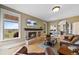 Comfortable living room with hardwood floors, brick fireplace, and lots of natural light and a TV at 9 Amaranth Dr, Littleton, CO 80127