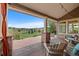 Spacious covered porch offering scenic views, comfortable seating, and outdoor dining area at 9 Amaranth Dr, Littleton, CO 80127