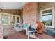 Inviting covered porch with seating, brick columns, and outdoor grill at 9 Amaranth Dr, Littleton, CO 80127