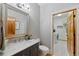 Stylish powder room with marble countertop, modern fixtures, and a view into laundry room at 9 Amaranth Dr, Littleton, CO 80127