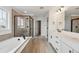 Modern bathroom featuring double vanity, soaking tub, and glass enclosed shower with contemporary finishes at 24768 E 40Th Ave, Aurora, CO 80019