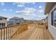 A wooden deck showcases the backyard of the home, with views of neighboring houses under a partially cloudy sky at 24768 E 40Th Ave, Aurora, CO 80019