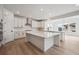 Modern kitchen with white cabinets, stainless appliances, large island, and eat-in nook at 24768 E 40Th Ave, Aurora, CO 80019