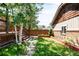 Cozy backyard featuring a wooden deck, small grassy area, stone pathway and wooden fence at 315 S Franklin St, Denver, CO 80209