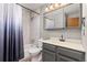 The renovated bathroom features a tub with a shower and a vanity with stylish lighting at 3238 W 11Th Avenue Pl, Broomfield, CO 80020
