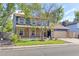 Inviting two-story home with a brick and blue facade, complemented by a lush green lawn and mature trees at 3238 W 11Th Avenue Pl, Broomfield, CO 80020