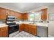 Well-lit kitchen featuring stainless steel appliances, wooden cabinets, and durable tile flooring at 3238 W 11Th Avenue Pl, Broomfield, CO 80020