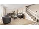 Inviting living room with a staircase, neutral walls, plush carpet, and a dining area in the background at 3238 W 11Th Avenue Pl, Broomfield, CO 80020