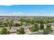 Aerial view of homes surrounded by green trees with mountain views in the distance at 21064 Woodside Ln, Parker, CO 80138