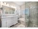 Bright bathroom with double vanity, glass shower, soaking tub, and neutral tile at 21064 Woodside Ln, Parker, CO 80138