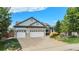 Beautiful home showcasing meticulous landscaping and a spacious driveway leading to a three-car garage at 21064 Woodside Ln, Parker, CO 80138