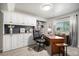 Well-lit home office with custom built-ins, a large desk, and ample storage space at 21064 Woodside Ln, Parker, CO 80138