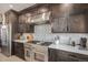 Gourmet kitchen featuring stainless steel appliances, dark cabinetry, and a decorative backsplash at 21064 Woodside Ln, Parker, CO 80138