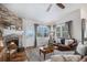 Cozy living room featuring a stone fireplace, hardwood floors, and natural light at 21064 Woodside Ln, Parker, CO 80138