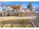 A beautiful backyard featuring a stone wall, two decks, and a green lawn at 7035 S Picadilly St, Aurora, CO 80016