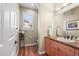 Well-lit half bath with decorative vanity, wood floors, and plantation shutters at 7035 S Picadilly St, Aurora, CO 80016