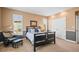 Cozy bedroom with neutral walls, a full-sized bed, large windows, and an accent chair at 7035 S Picadilly St, Aurora, CO 80016